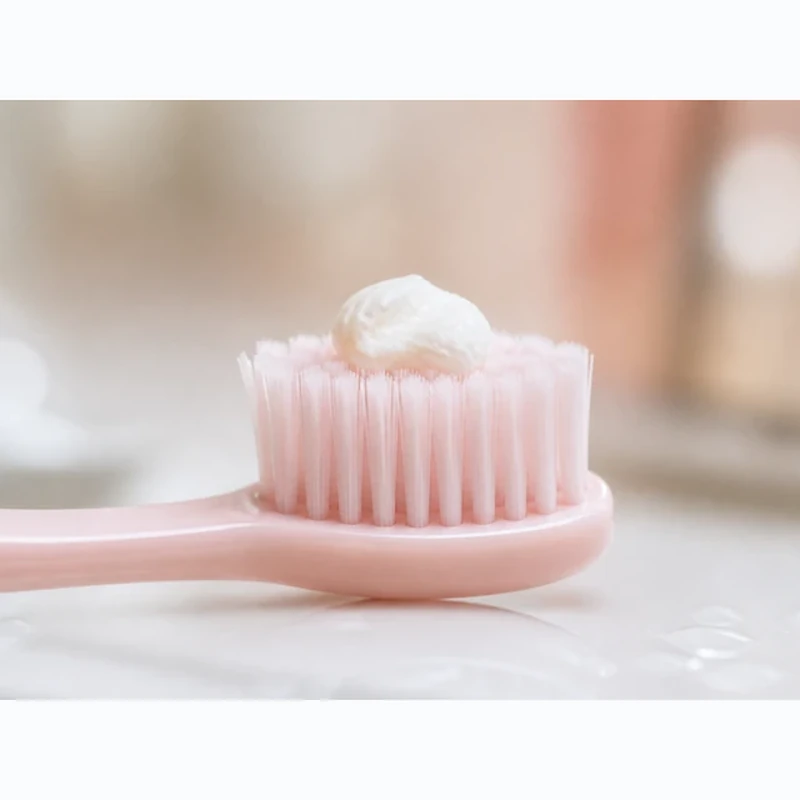 RiseWell toothpaste squeezed onto a pink toothbrush
